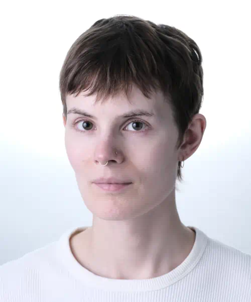 Me, with short brown hair, in a white t-shirt against a plain white background